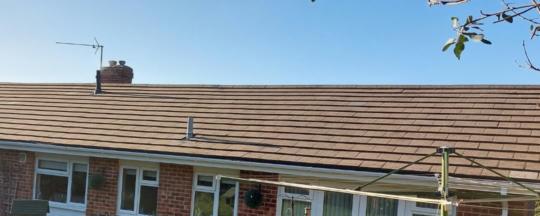 The same bungalow roof after a Blue Shield clean, the tiles back to their original colour